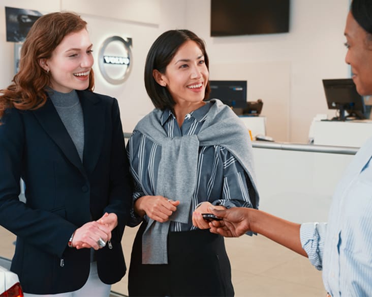 Volvo Care Select three women talking as one hands the other car keys