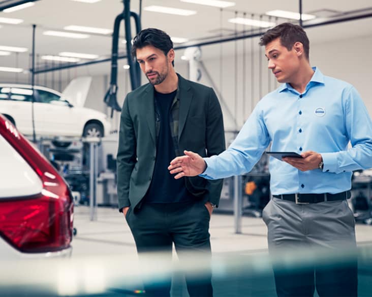 Wear Maintenance 2 men looking at a volvo inside of a shop